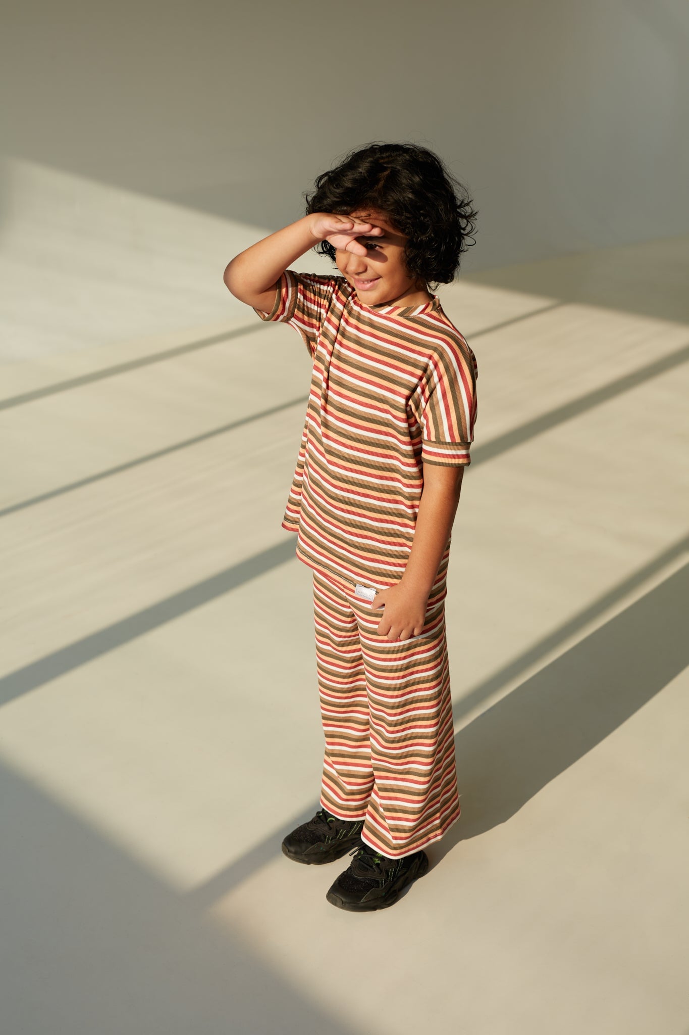 Sunset Stripes grow-with-me t-shirt for kids, made from soft organic cotton with a stretchy, foldable waistband. Ethically made in Canada for a sustainable and comfy fit.