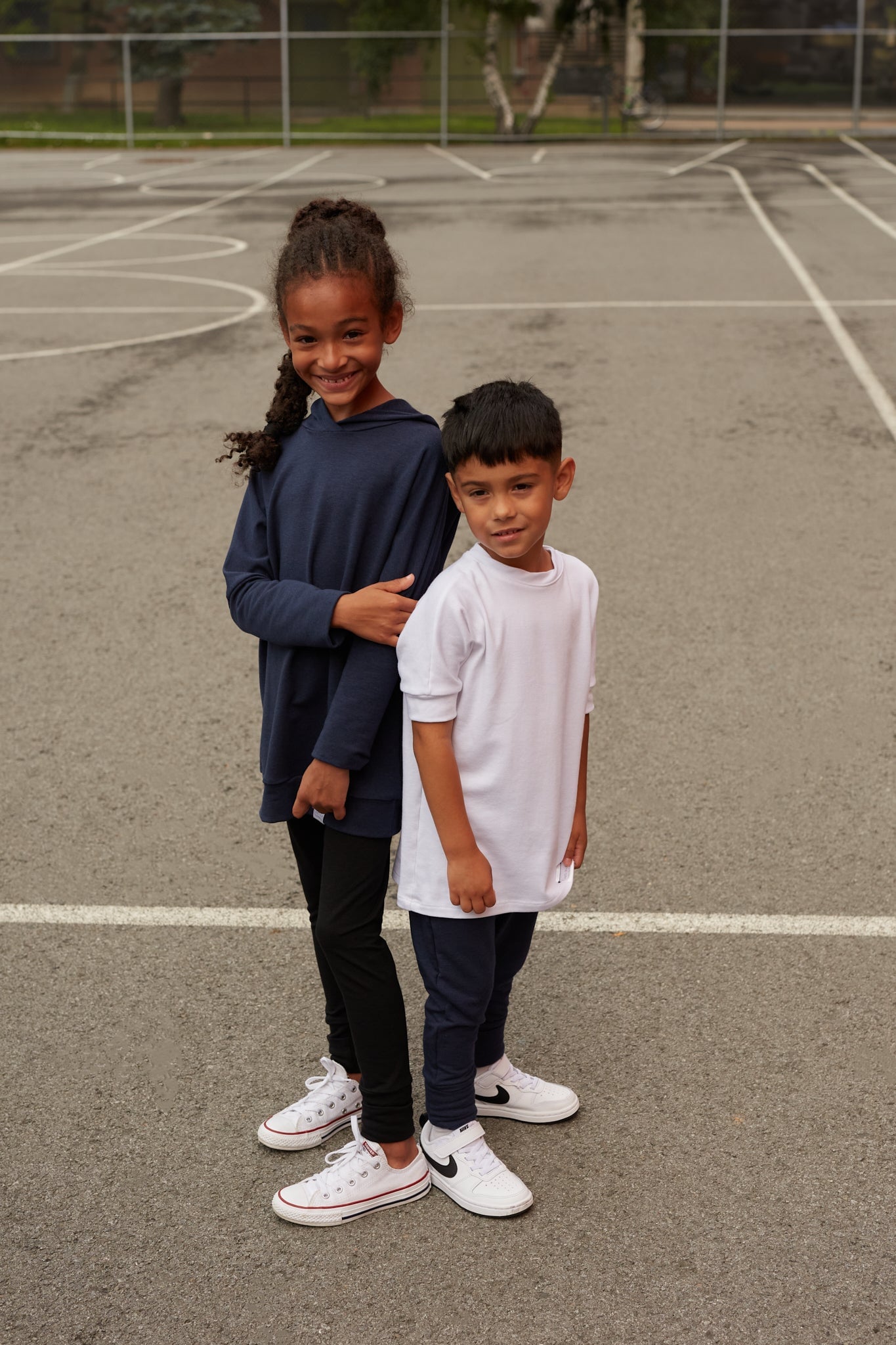 White grow-with-me t-shirt for kids, made from soft organic cotton with a stretchy, foldable waistband. Ethically made in Canada for a sustainable and comfy fit.