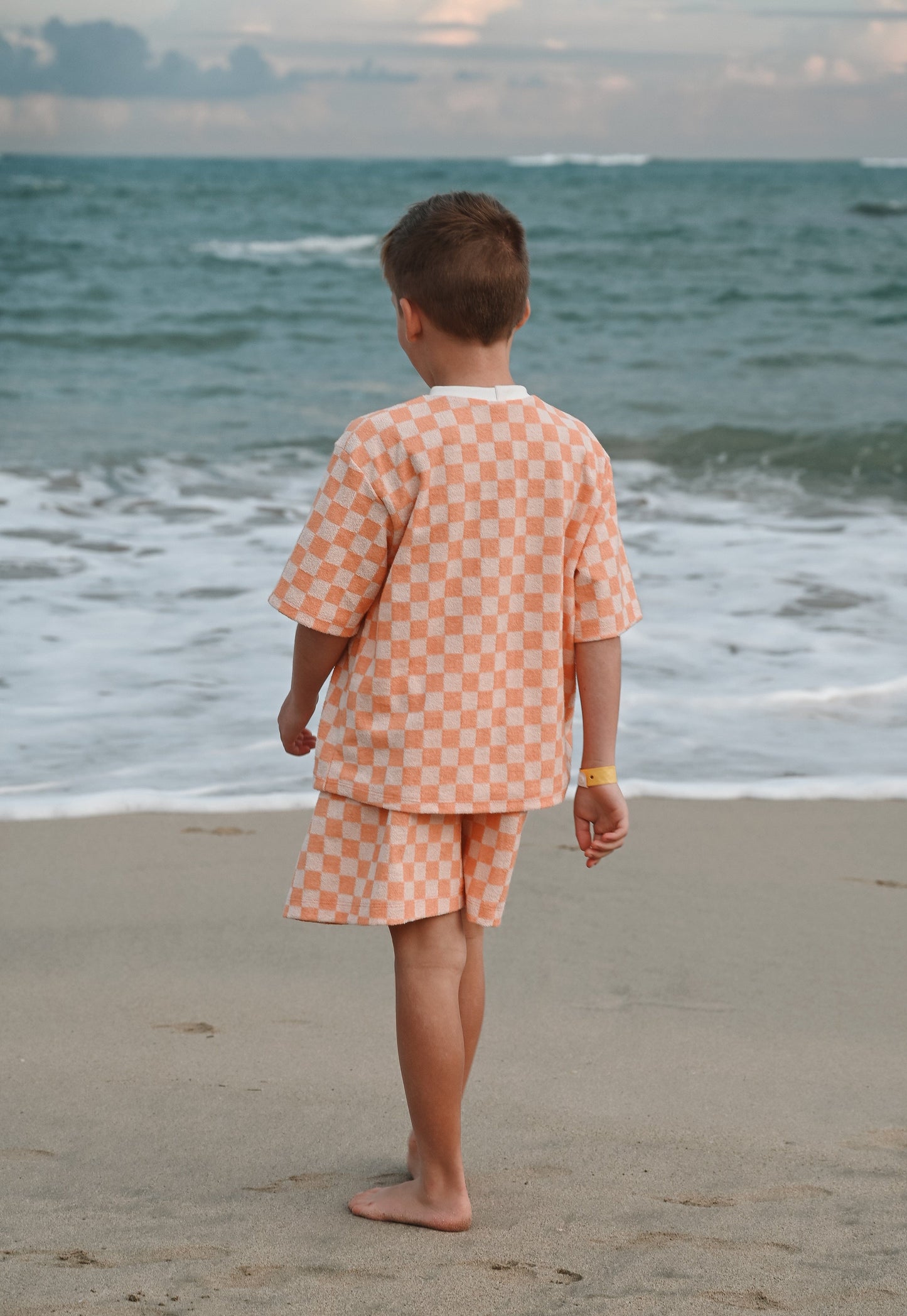 Checkered orange loose kids short made in Canada with eco-friendly fabric designed to grow with your child