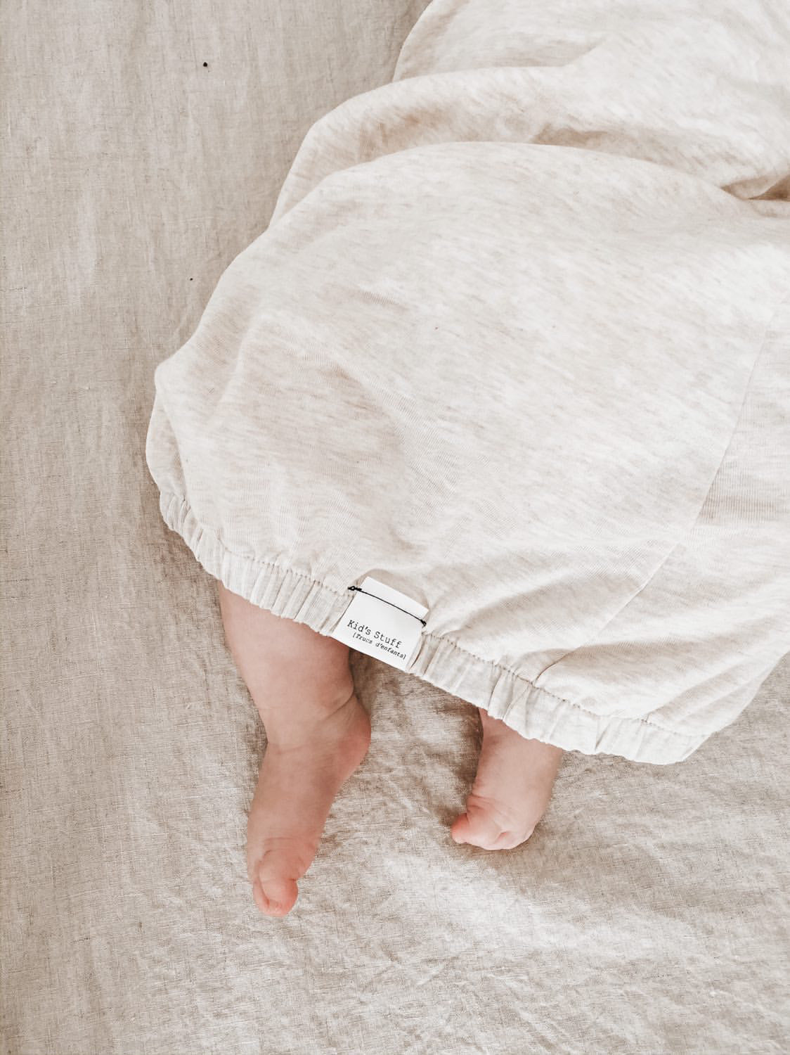 Eco-friendly kids' clothing – gender-neutral heather cream newborn gown, sustainably made in Canada.