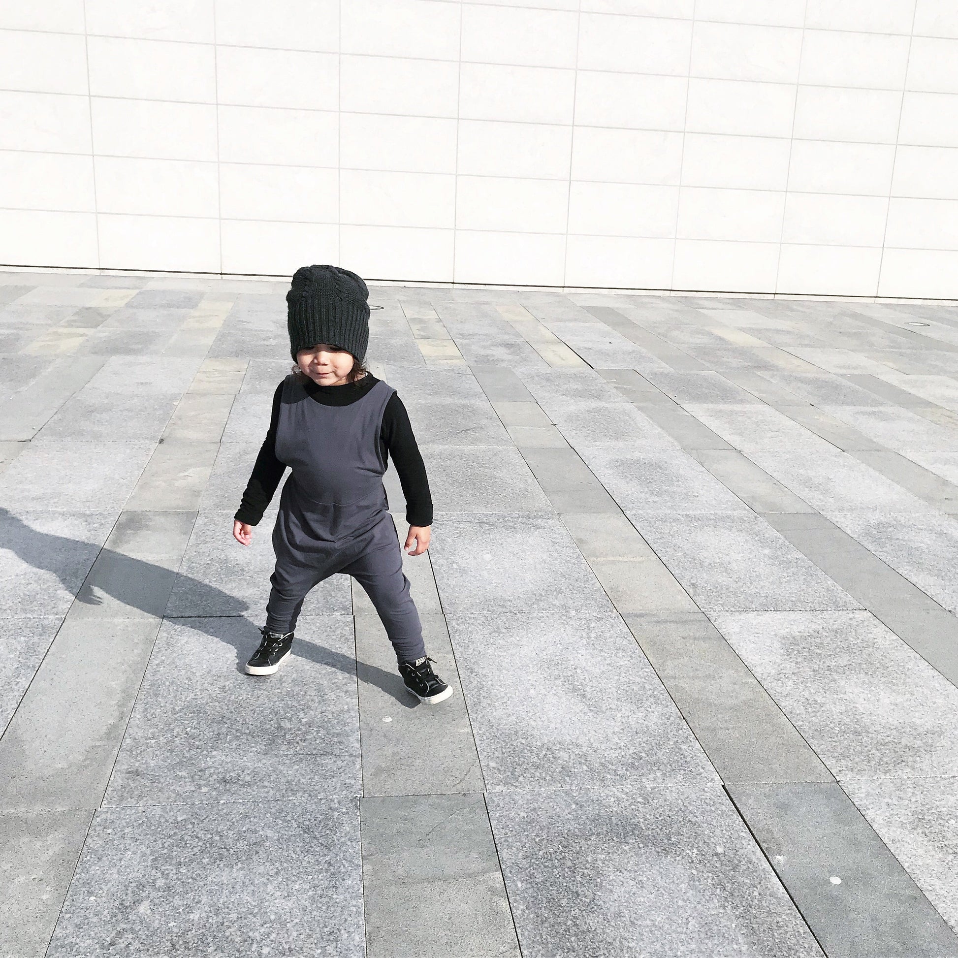 Dark grey grow-with-me overalls for toddlers and kids, made from soft, eco-friendly fabric. Adjustable straps and cuffs for a long-lasting fit. Ethically made in Canada.