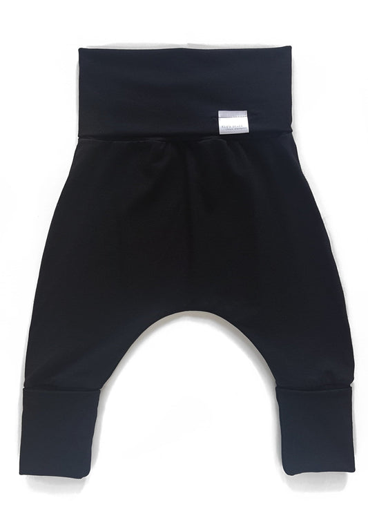 Black grow-with-me pants for toddlers and kids, made from soft, eco-friendly fabric. Adjustable waistband and cuffs for extended wear. Ethically made in Canada.