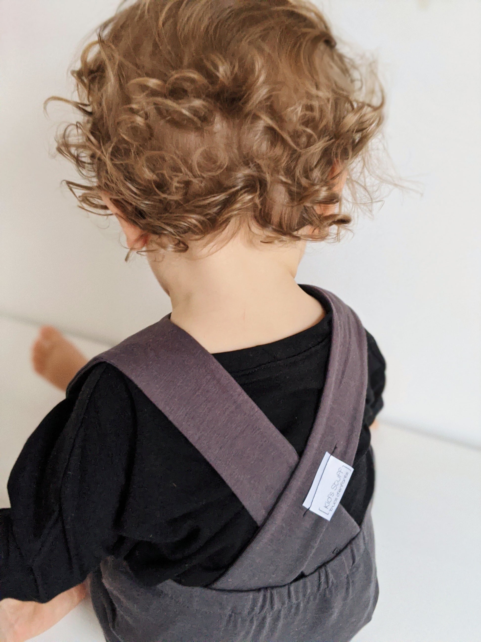 Dark grey grow-with-me overalls for toddlers and kids, made from soft, eco-friendly fabric. Adjustable straps and cuffs for a long-lasting fit. Ethically made in Canada.