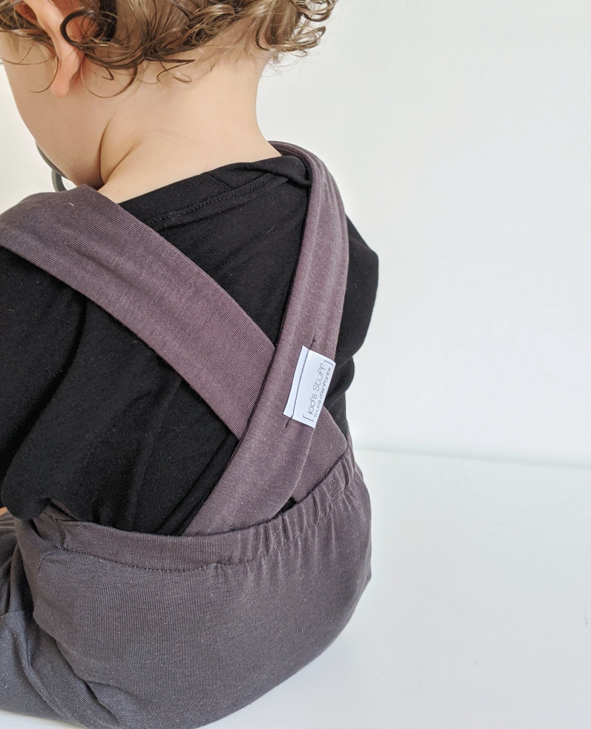 Dark grey grow-with-me overalls for toddlers and kids, made from soft, eco-friendly fabric. Adjustable straps and cuffs for a long-lasting fit. Ethically made in Canada.