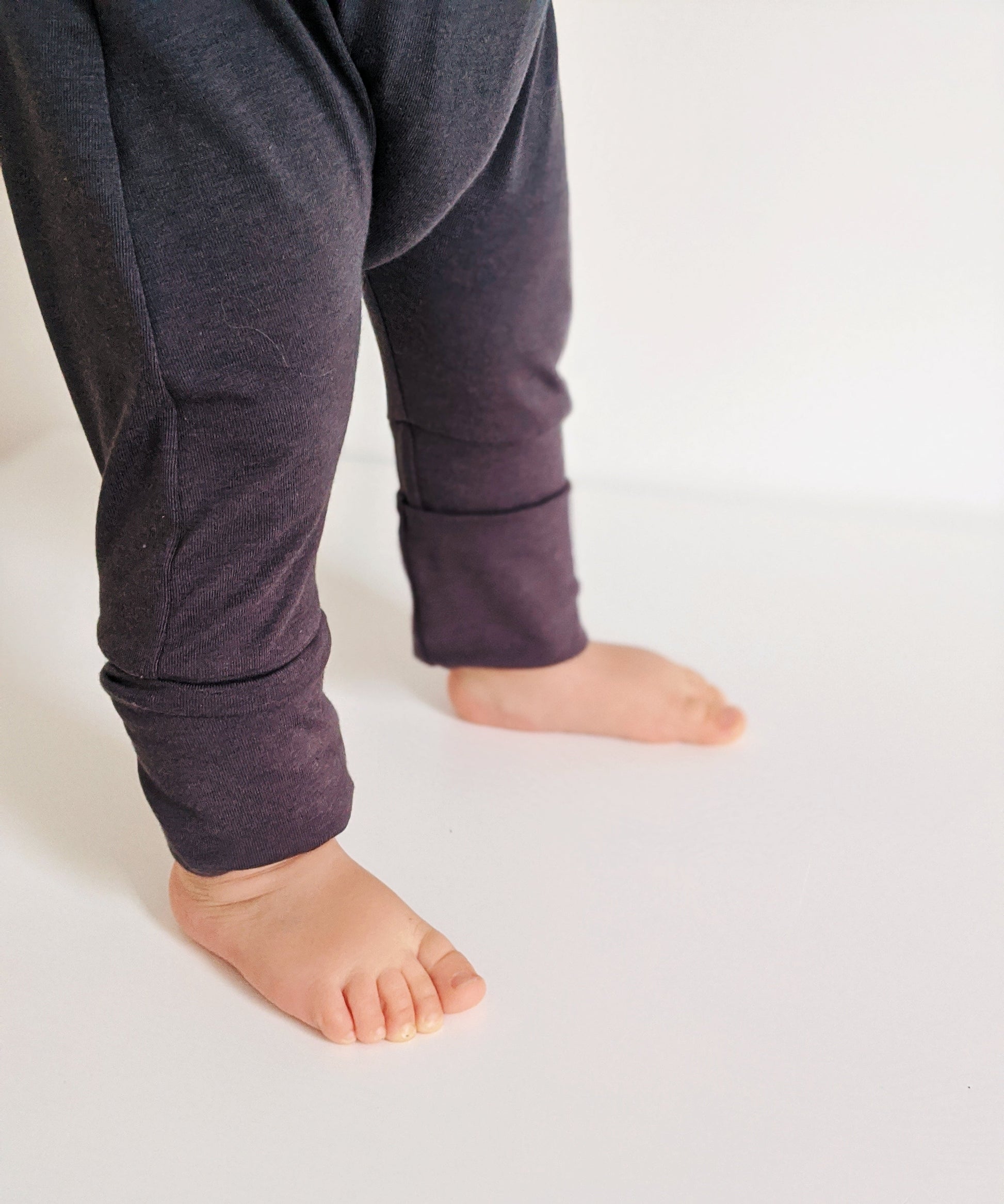 Dark Grey grow-with-me pants for toddlers and kids, made from soft, eco-friendly fabric. Adjustable waistband and cuffs for extended wear. Ethically made in Canada.