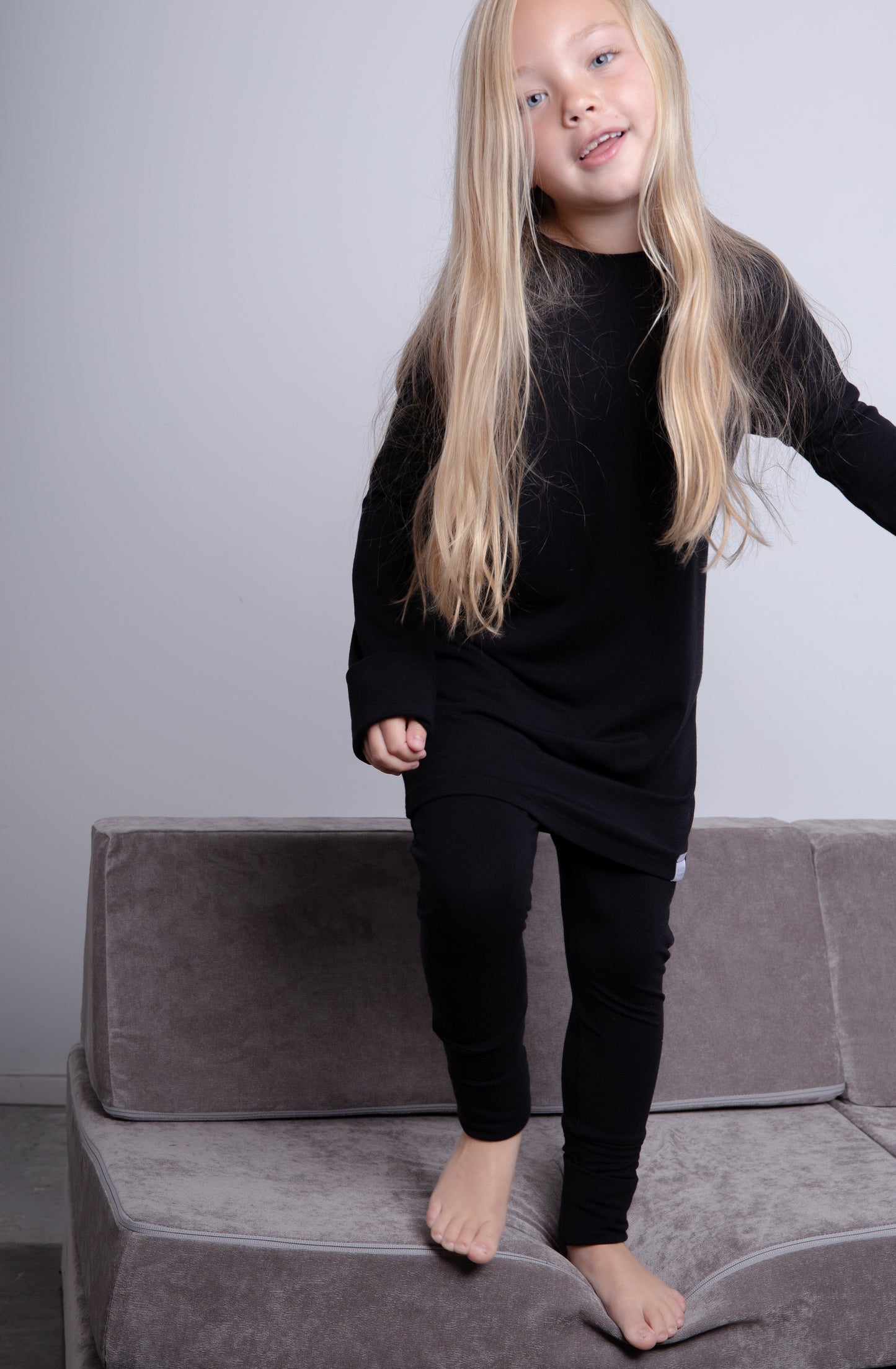 Black grow-with-me shirt for toddlers and kids, designed to be worn as a dress, tunic, or long shirt. Seamless shoulders and soft, eco-friendly fabric. Ethically made in Canada.