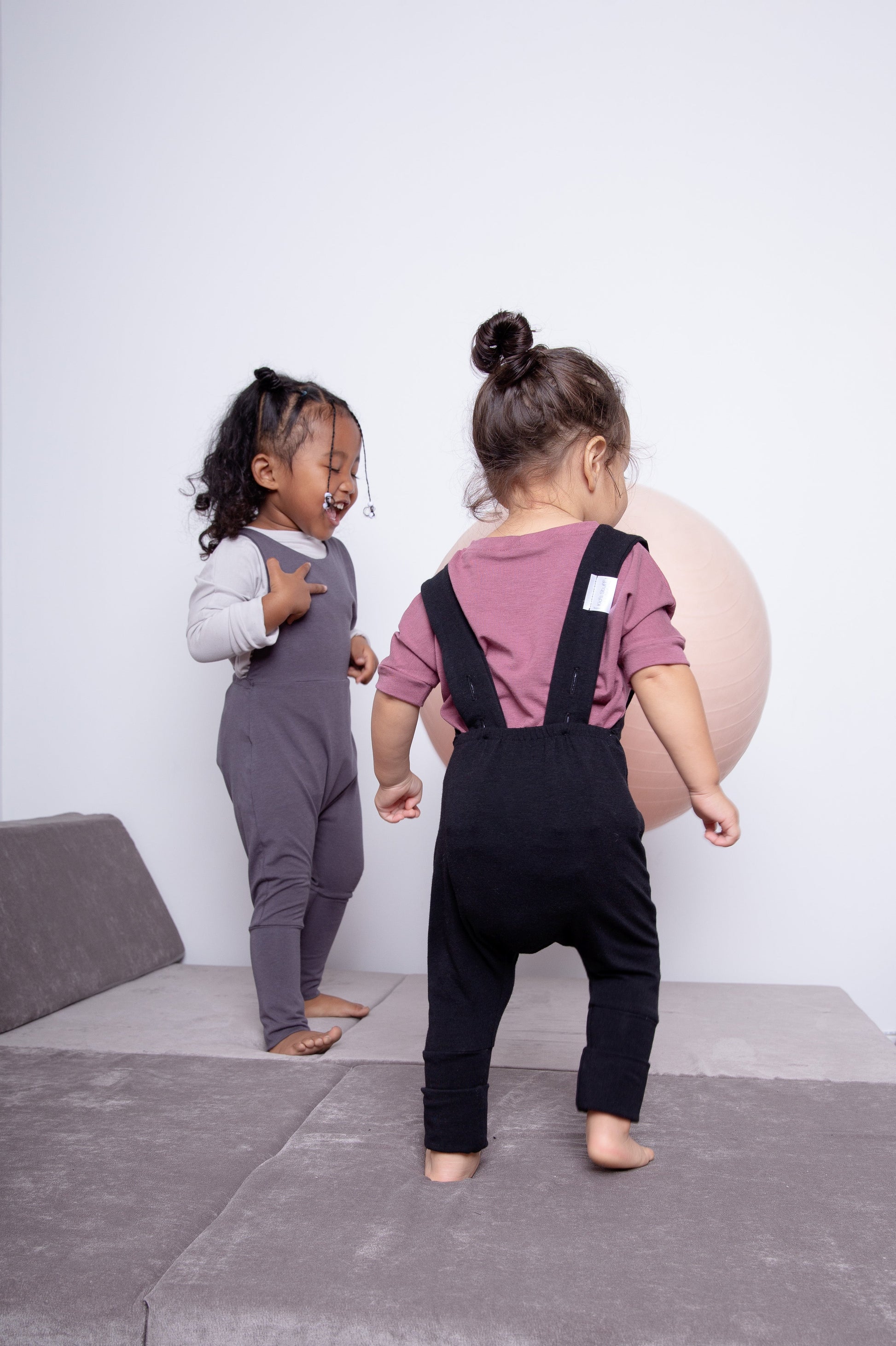 black grow-with-me overalls for toddlers and kids, made from soft, eco-friendly fabric. Adjustable straps and cuffs for a long-lasting fit. Ethically made in Canada.