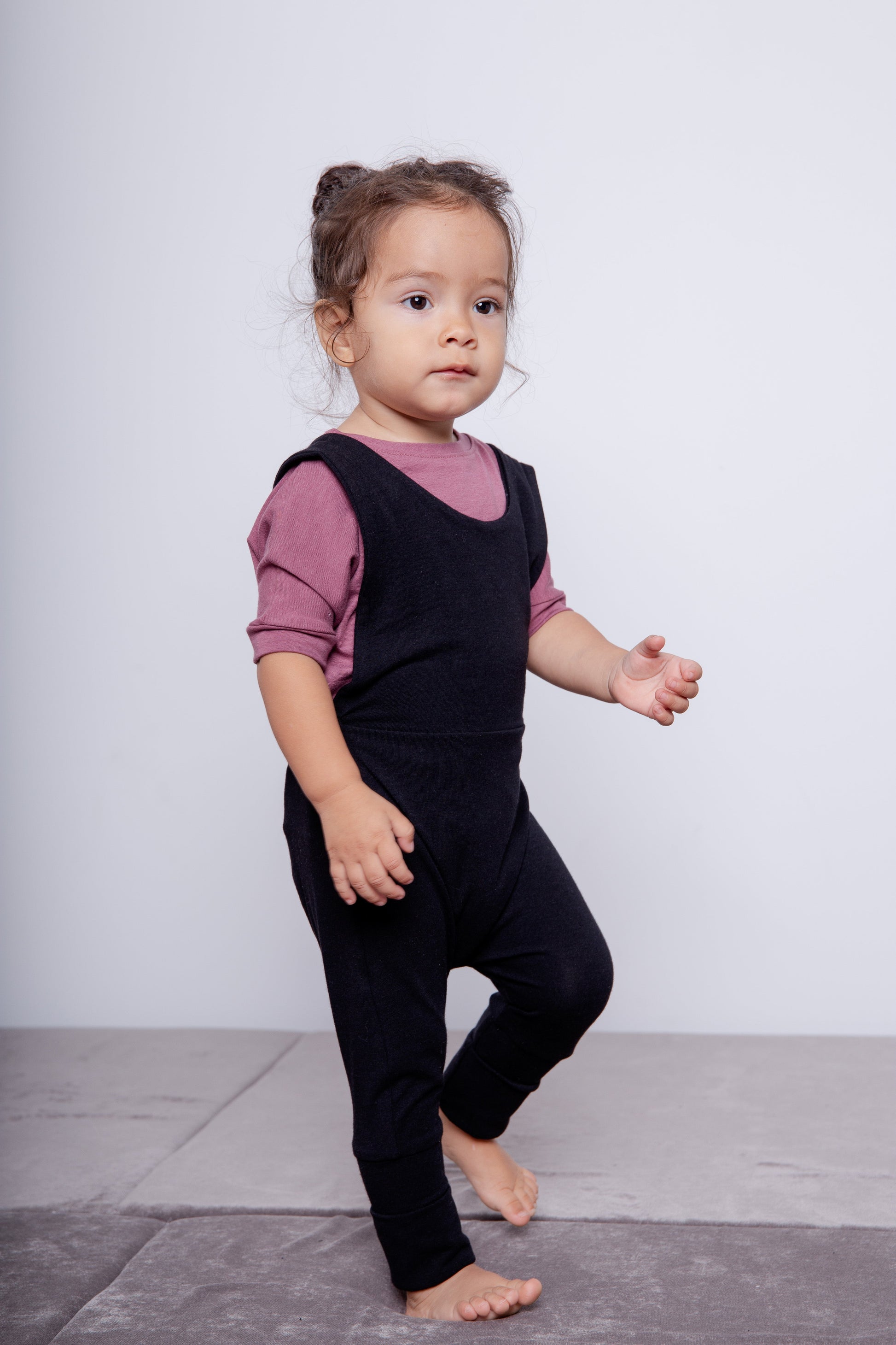 black grow-with-me overalls for toddlers and kids, made from soft, eco-friendly fabric. Adjustable straps and cuffs for a long-lasting fit. Ethically made in Canada.