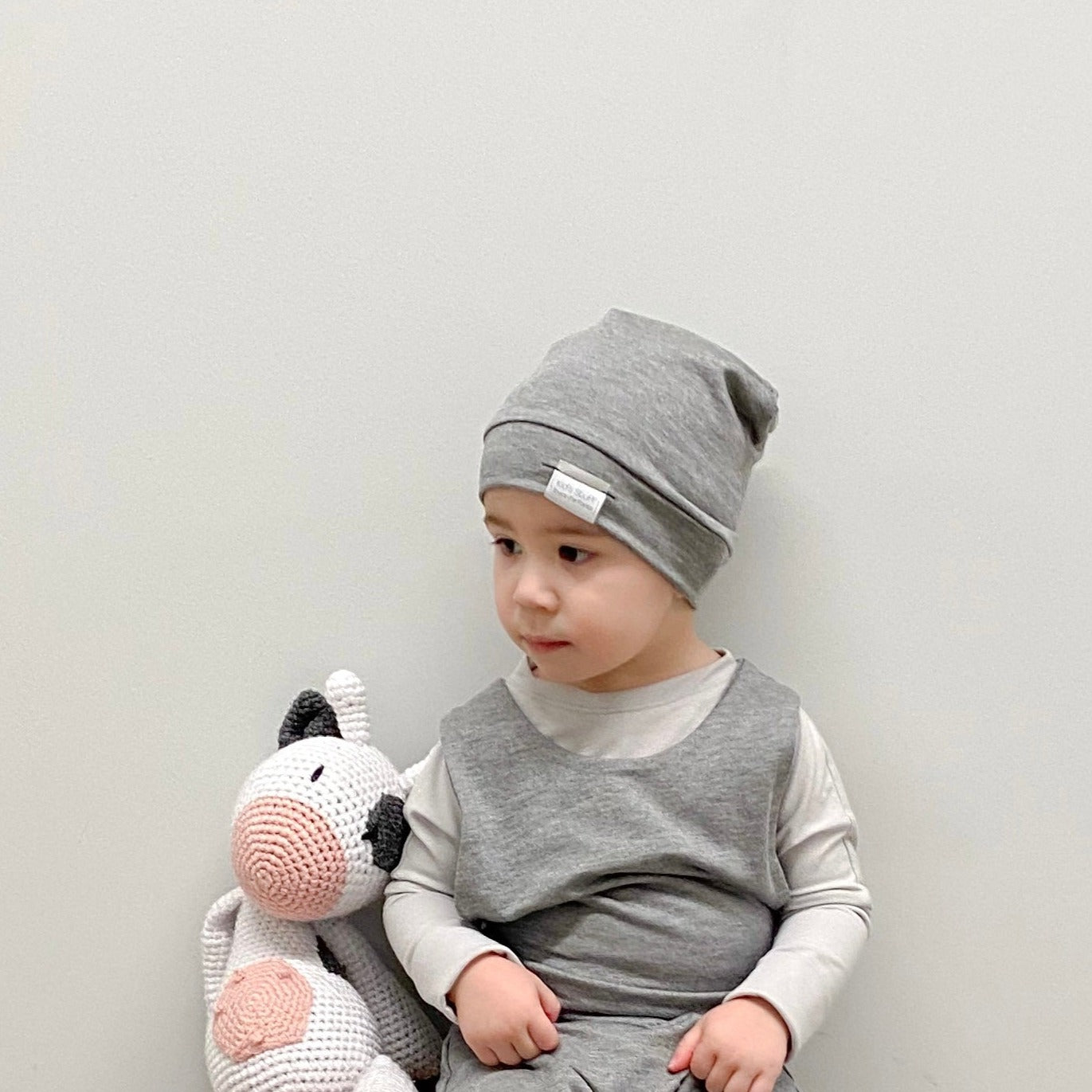 Soft and stretchy grey cloud beanie for kids, made from eco-friendly fabric. Ethically crafted in Canada, featuring a fold-over brim and minimalist design