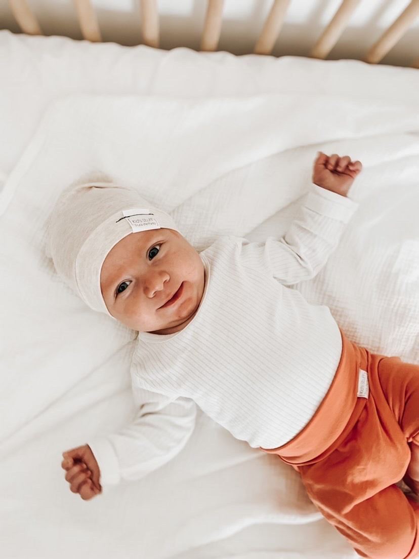 Soft and stretchy Heather cream  beanie for kids, made from eco-friendly fabric. Ethically crafted in Canada, featuring a fold-over brim and minimalist design