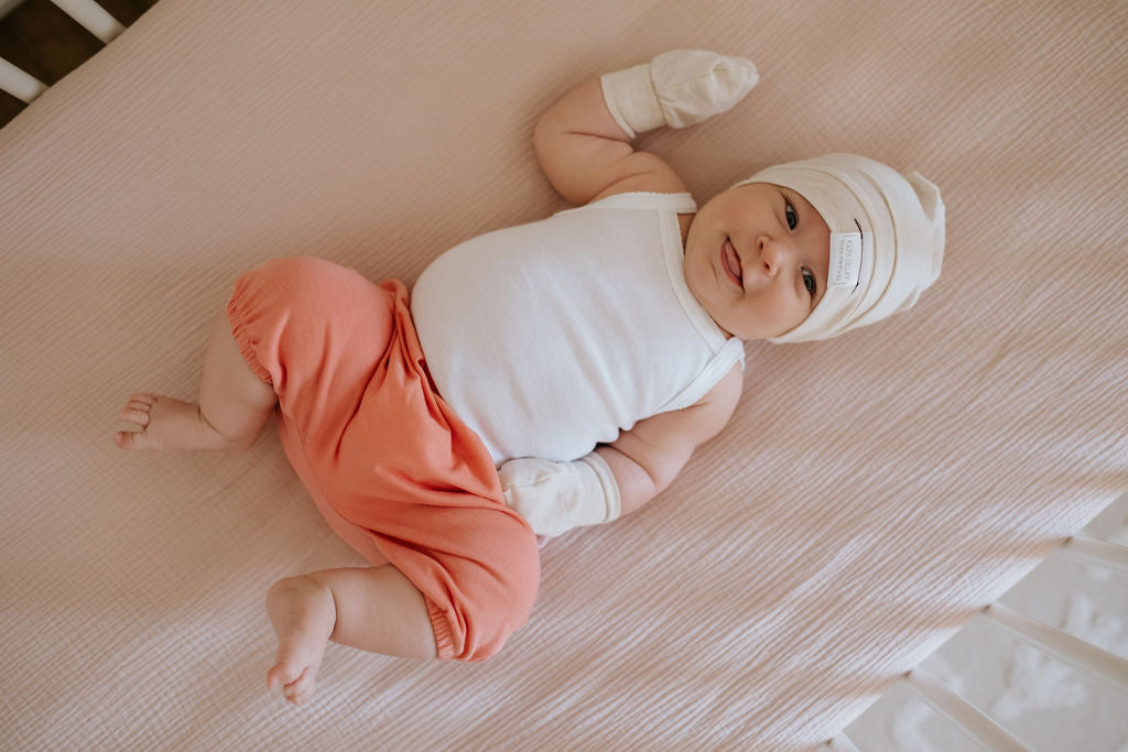 Soft and stretchy Heather cream  beanie for kids, made from eco-friendly fabric. Ethically crafted in Canada, featuring a fold-over brim and minimalist design