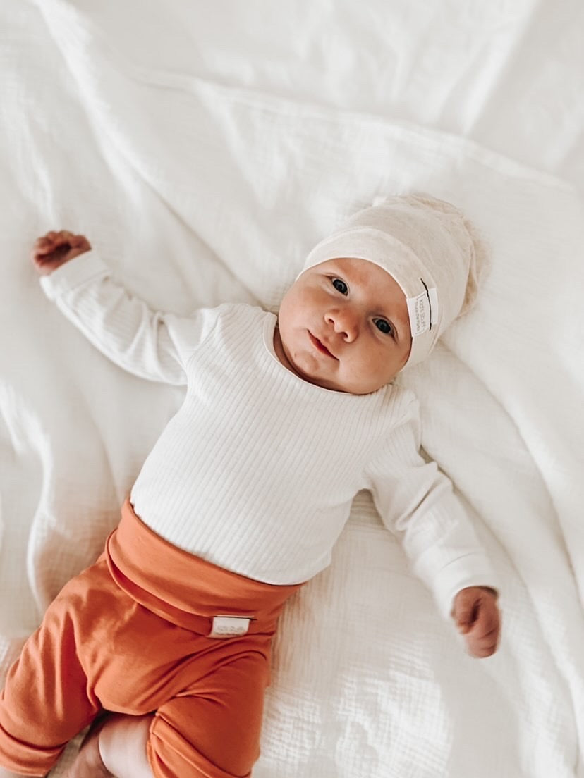 Soft and stretchy Heather cream  beanie for kids, made from eco-friendly fabric. Ethically crafted in Canada, featuring a fold-over brim and minimalist design