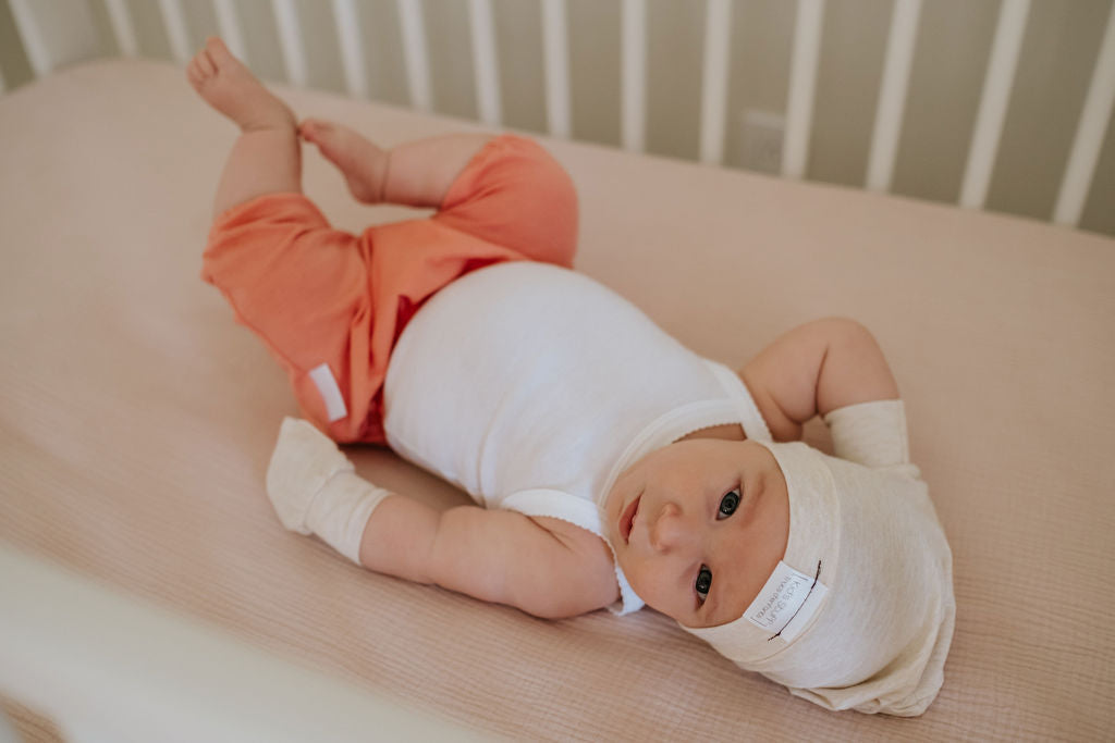 Soft and stretchy Heather cream  beanie for kids, made from eco-friendly fabric. Ethically crafted in Canada, featuring a fold-over brim and minimalist design