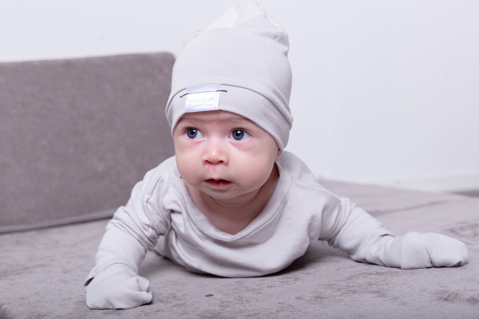 Soft and stretchy taupe beanie for kids, made from eco-friendly fabric. Ethically crafted in Canada, featuring a fold-over brim and minimalist design