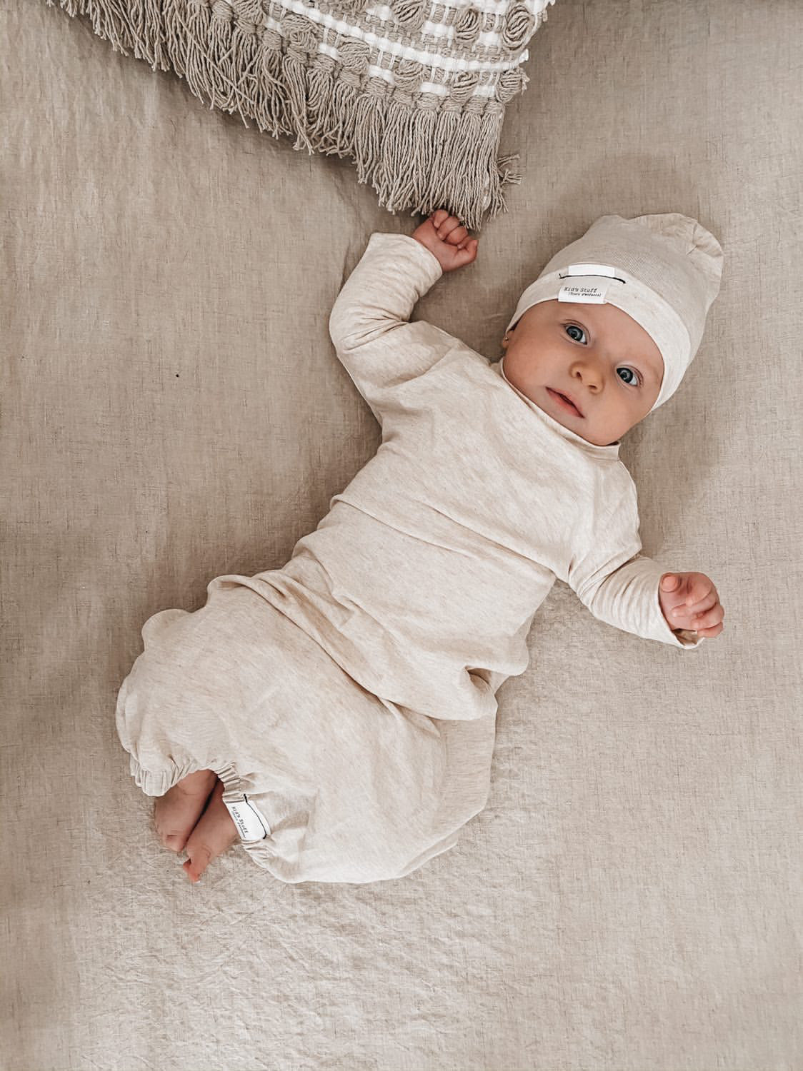Soft and stretchy Heather cream  beanie for kids, made from eco-friendly fabric. Ethically crafted in Canada, featuring a fold-over brim and minimalist design